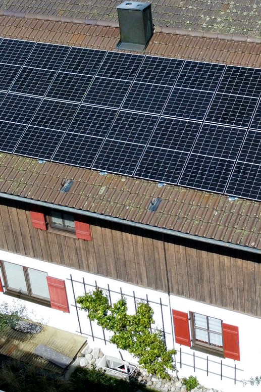 Draufsicht auf eine Reihe von Photovoltaikmodulen auf einem Hausdach